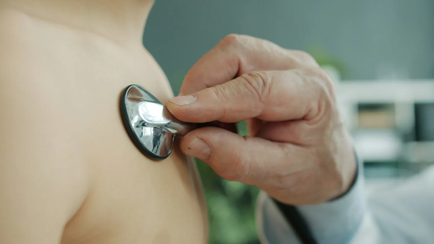 Médico ausculta o peito de um paciente com o estetoscópio